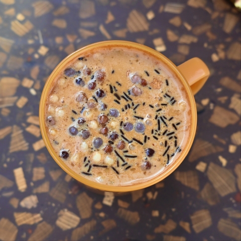 A mug of coffee sprinkled with chocolate sprinkles