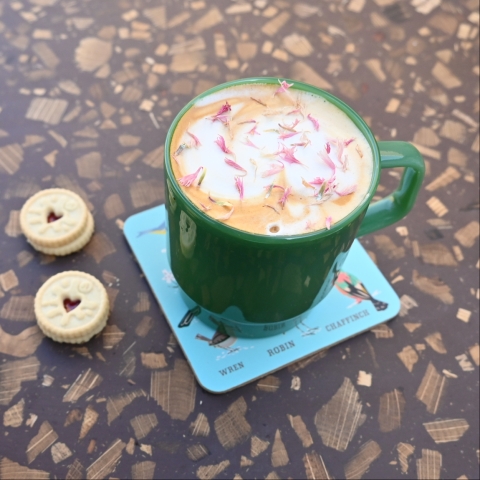 A mug of coffee sprinkled with edible flowers