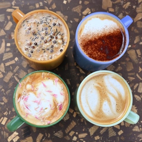 A top-down shot of four coffee mugs, each decorated in a different style