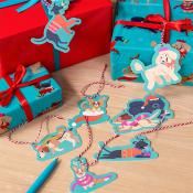 Set of colorful Christmas tree decorations dogs shaped, laid out next to wrapped presents.