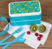 Turquoise plastic bento box with cream lid and middle tray featuring print of cheetahs
