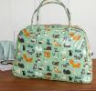 Light green oilcloth weekend bag with illustrations of cats