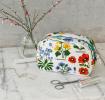 White oilcloth makeup bag with images of wild flowers