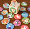 Multi-coloured memory game pieces with illustrations of animals on table with box