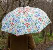 White umbrella with wild flower pattern used by person outside