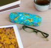 Turquoise hardshell glasses case with print of cheetahs on table
