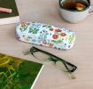 White hardshell glasses case with wild floral pattern on table