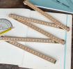 Wooden folding ruler partially unfolded on exercise book