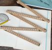 Wooden folding ruler partially unfolded on exercise book