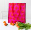 Recycled plastic shopping bag red circles pink background