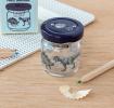 Glass jar pencil sharpener with dinosaurs print on desk with pencils