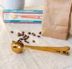 Gold coloured metal coffee scoop with bag clip