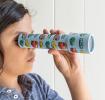 Child looking through kaleidoscope with print of vintage cars and other vehicles