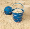 Sharks tin bucket containing sand alongside play ball and sandcastles