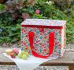 Tilde lunch bag outside on garden bench alongside macarons, strawberry and grapes