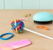 Multi-coloured hairbands on lollipop stick on table with hair clips, hair brush and comb