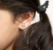 girl wearing small white skull-shaped earring
