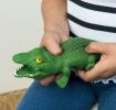 Child squeezing a green crocodile toy