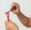 Red slingshot with a sticky, poop-shaped held by a child
