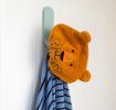 Lion-themed orange bath hat with ears hanging on a wall
