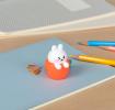 Rabbit-shaped pencil sharpener with coloured pencils placed beside