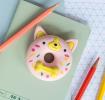 Doughnut-shaped dog eraser placed on a notebook beside coloured pencils