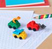 Four construction vehicles-shaped erasers in different styles and colours