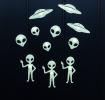 Glowing aliens and a flying saucer on a black background