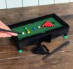 Table top snooker game set up with balls, cues, and rack