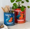 Two large Cerveza Española tins used as utensil holder and plant pot.