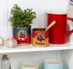 Two passata tins repurposed as herb and spice holders on a rustic kitchen shelf.