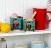 Cornish Sea Salt and Seaweed Pepper tins repurposed as kitchen storage on a shelf.