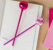 two dsico ball pens in pink placed on a notebook