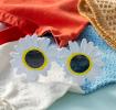 funglasses with a white daisy-shaped frame and dark lenses.