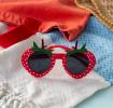 Red strawberry-shaped funglasses with green leaves, and dark round lenses