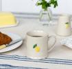 Stoneware mug featuring a yellow lemon print with green leaves and handle 