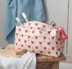 Rectangular makeup bag in pale pink with a floral pattern of small red and green flowers