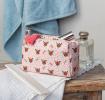 Rectangular makeup bag in pale pink with a floral pattern of small red and green flowers with tag