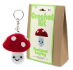 Crochet kit packaging displayed next to a finished red and white toadstool mushroom keychain