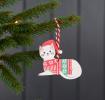 Wooden Christmas decoration of white cat wearing festive jumper and hat hanging on tree