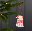 Wooden hanging Christmas decoration of pug dog wearing festive jumper and hat hanging on tree