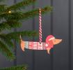 Wooden Christmas decoration of sausage dog wearing festive jumper and hat hanging on tree