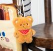Light brown plush teddy bear keychain with a red polka-dotted bandana, metal clasp for attachment