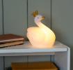 White swan night light wearing a crown shown with light on