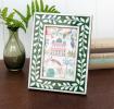 picture frame with a green border and white leaf patterns