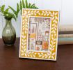picture frame with a mustard yellow border and white leaf patterns