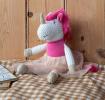 Knitted unicorn toy wearing a pink top and skirt