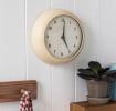 Round cream wall clock with black hands and numbers