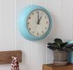 Round blue wall clock with black hands and numbers