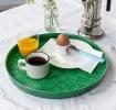 Round enamel trinket tray in dark green displayed with cup of coffee, orange juice and egg.